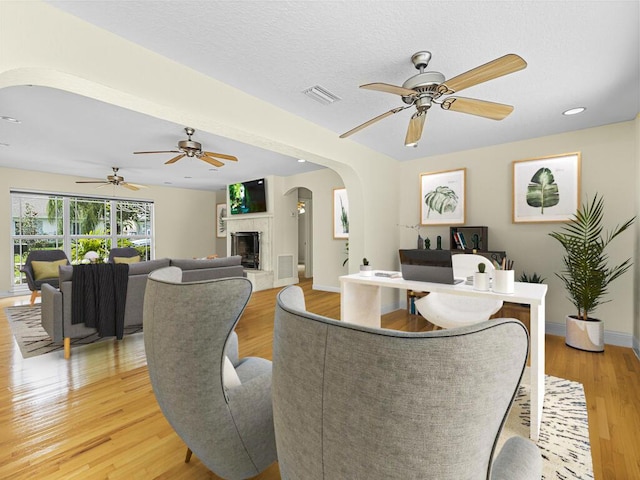 living room with light hardwood / wood-style flooring and ceiling fan