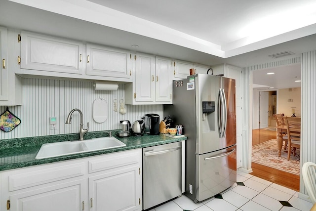 kitchen featuring sink, white cabinets, stainless steel appliances, and light hardwood / wood-style floors