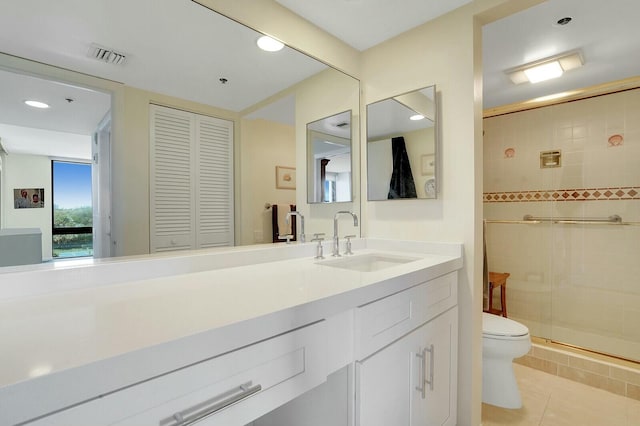 bathroom with tile patterned flooring, vanity, toilet, and an enclosed shower