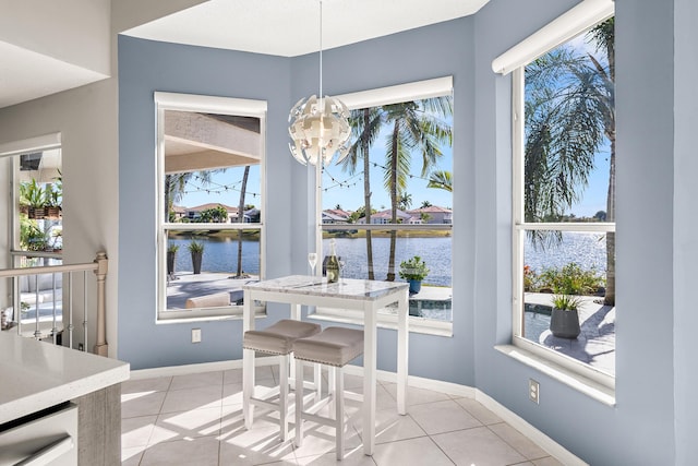 dining area featuring a water view and light tile patterned floors