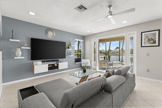 tiled living room with ceiling fan and a textured ceiling