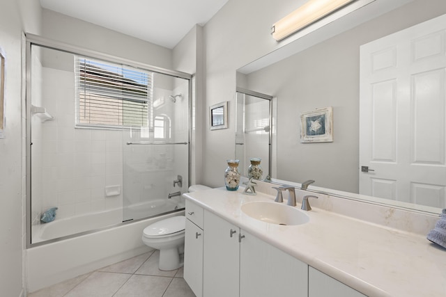 full bathroom featuring shower / bath combination with glass door, tile patterned floors, vanity, and toilet