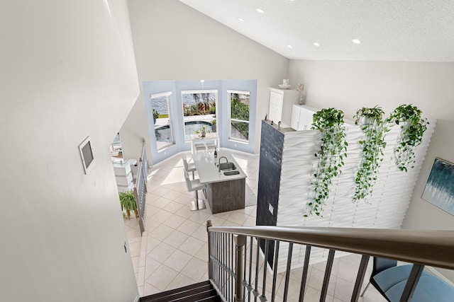 stairs featuring tile patterned floors, a textured ceiling, and high vaulted ceiling