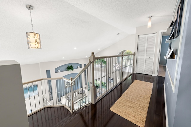 hallway featuring dark hardwood / wood-style floors and lofted ceiling