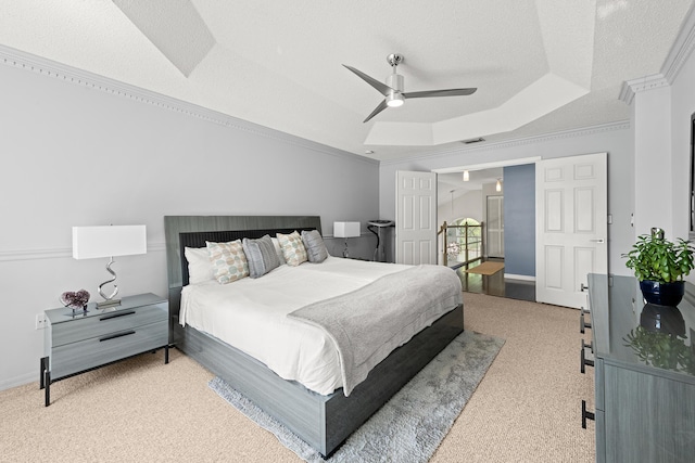 bedroom with light carpet, a textured ceiling, a tray ceiling, ceiling fan, and crown molding