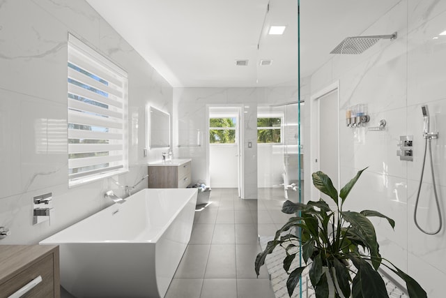 bathroom with tile patterned floors, vanity, tile walls, and independent shower and bath