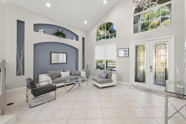 tiled living room with a chandelier, french doors, high vaulted ceiling, and a wealth of natural light