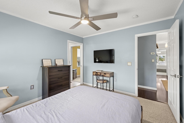 carpeted bedroom with ceiling fan, a textured ceiling, and ornamental molding