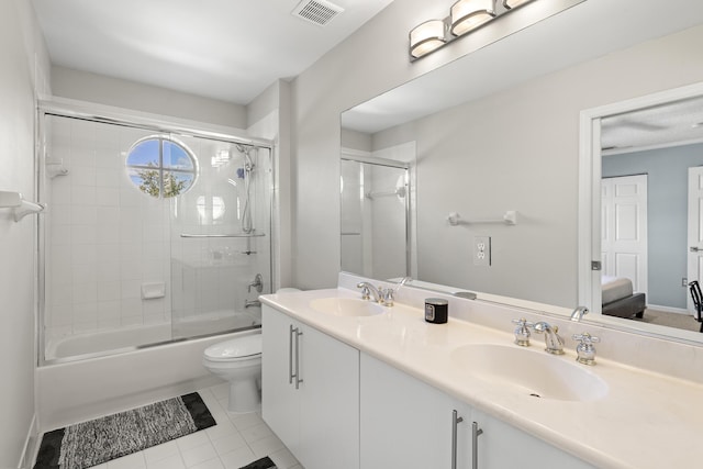 full bathroom featuring tile patterned flooring, vanity, enclosed tub / shower combo, and toilet