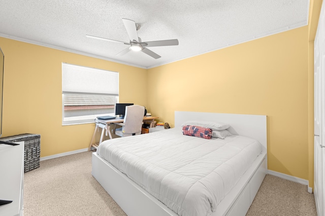 bedroom featuring a textured ceiling, light colored carpet, ceiling fan, and ornamental molding