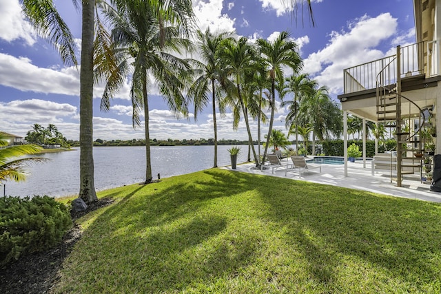 view of yard featuring a patio, a water view, and a balcony