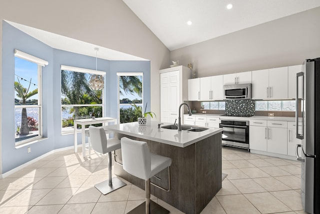 kitchen with white cabinetry, hanging light fixtures, stainless steel appliances, and sink