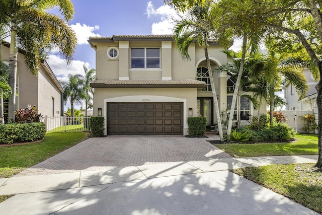 mediterranean / spanish-style house featuring a garage and a front yard