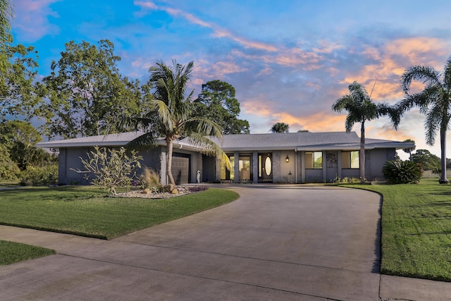 single story home with a yard and a garage