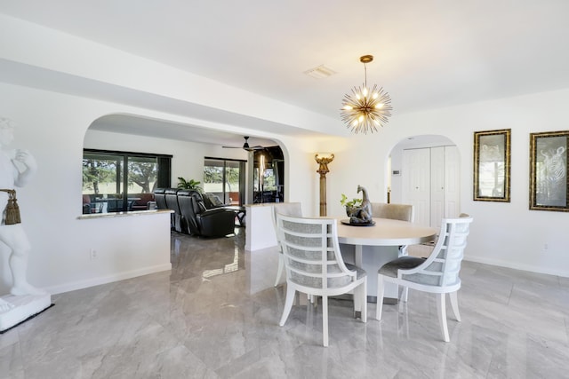 dining area featuring ceiling fan with notable chandelier