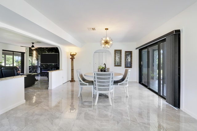 dining space with ceiling fan with notable chandelier