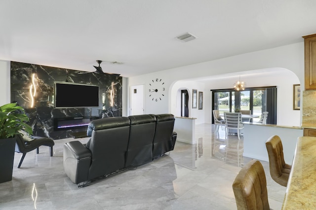 living room with ceiling fan with notable chandelier