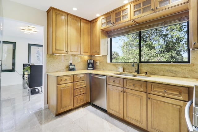 kitchen featuring stainless steel dishwasher, decorative backsplash, light stone counters, and sink