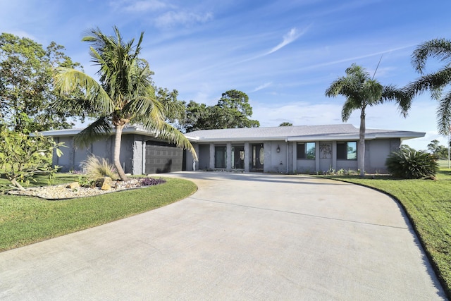 ranch-style house with a garage and a front lawn