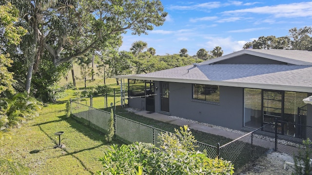 view of property exterior featuring a sunroom and a yard