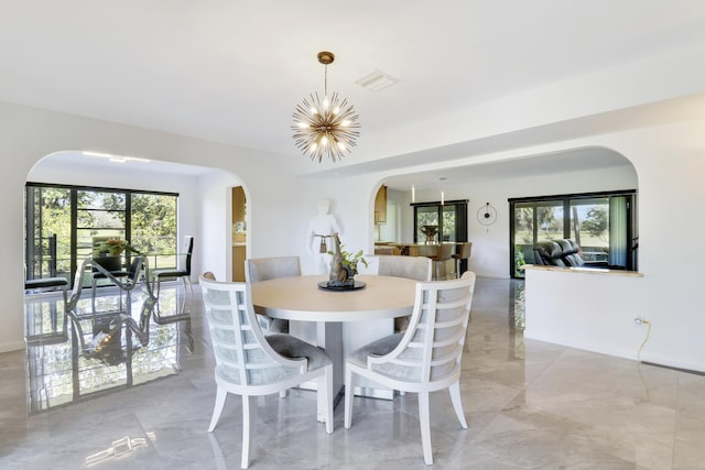 dining area featuring plenty of natural light and an inviting chandelier