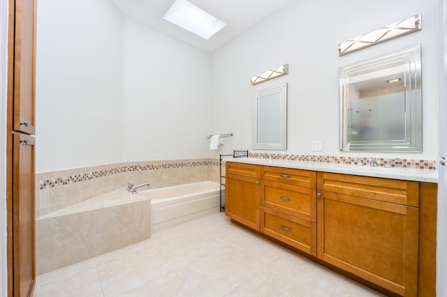 bathroom featuring tiled bath, tile patterned flooring, vanity, and a skylight