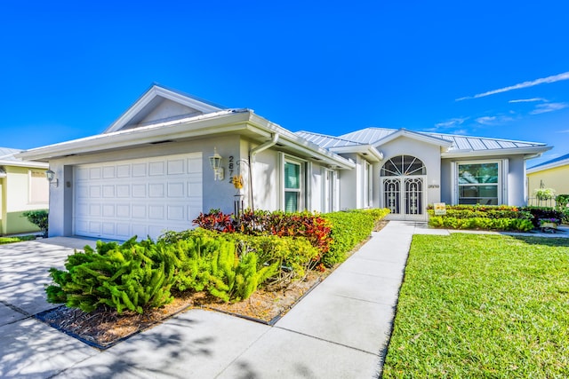 single story home with french doors, a front yard, and a garage