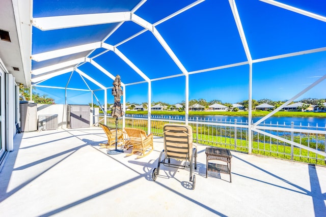 view of patio / terrace with cooling unit, glass enclosure, and a water view