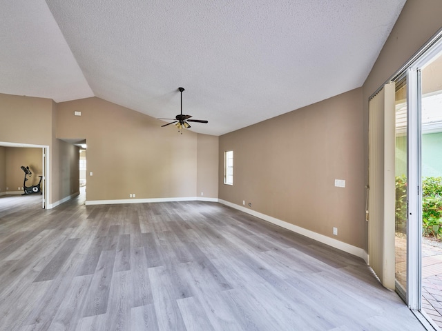 unfurnished living room with a textured ceiling, ceiling fan, light hardwood / wood-style flooring, and vaulted ceiling