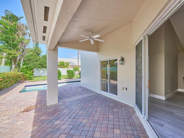 view of patio / terrace with a fenced in pool and ceiling fan