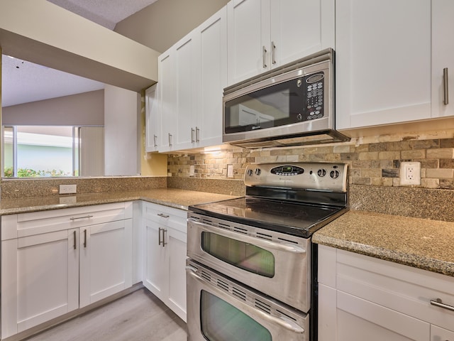 kitchen featuring light hardwood / wood-style floors, white cabinetry, light stone counters, and appliances with stainless steel finishes