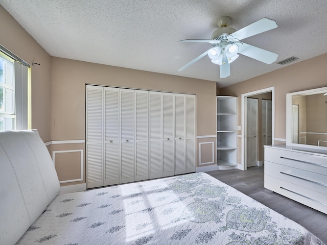 unfurnished bedroom with a textured ceiling, dark hardwood / wood-style flooring, and ceiling fan