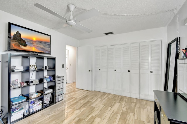 office area featuring ceiling fan, a textured ceiling, and light hardwood / wood-style flooring