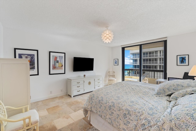 bedroom with floor to ceiling windows and a textured ceiling