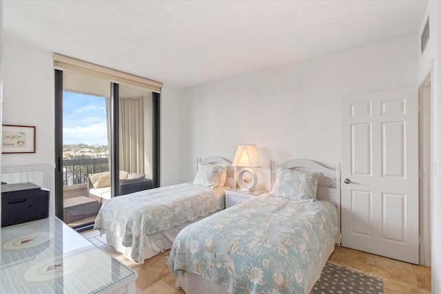 bedroom featuring a textured ceiling and access to outside