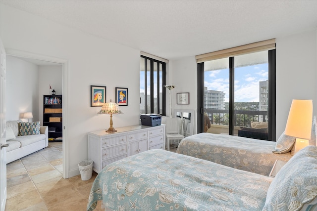 bedroom with light tile patterned floors, a textured ceiling, access to outside, and floor to ceiling windows