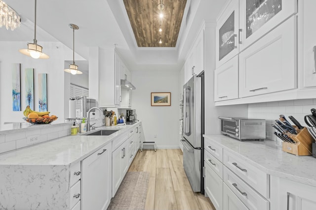 kitchen with white cabinets, light hardwood / wood-style flooring, and light stone counters