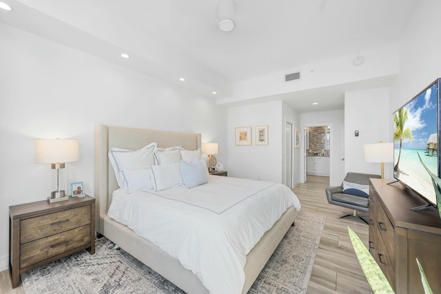 bedroom featuring light wood-type flooring and ensuite bathroom