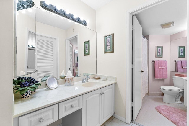 bathroom featuring tile patterned flooring, vanity, and toilet