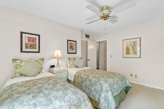 bedroom featuring light tile patterned floors, a textured ceiling, and ceiling fan