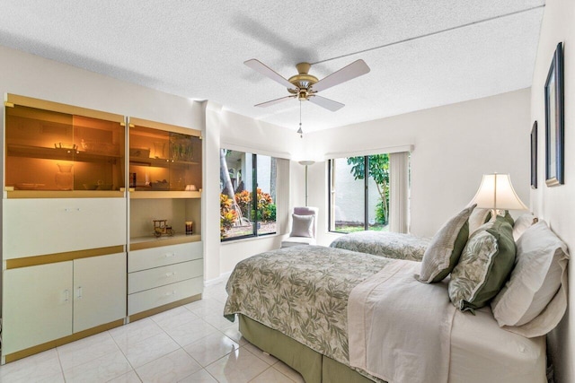 tiled bedroom featuring a textured ceiling and ceiling fan