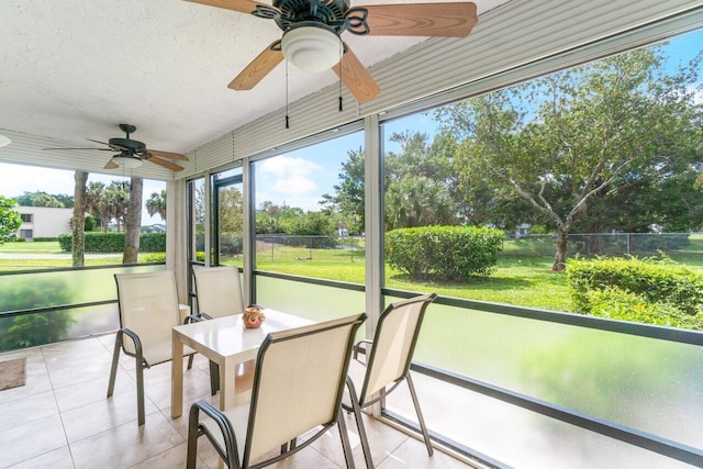 unfurnished sunroom featuring ceiling fan