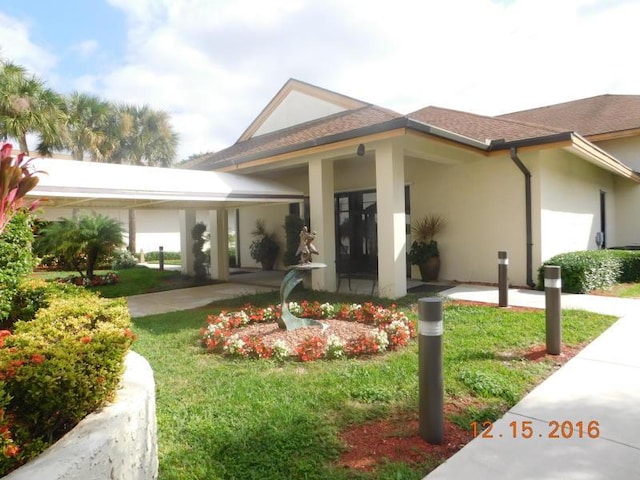 view of front of property with a carport and a front lawn