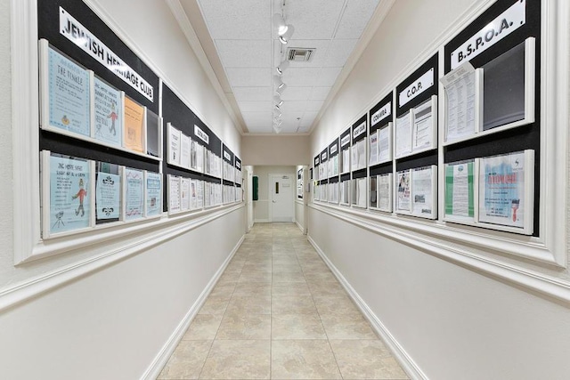 corridor featuring light tile patterned floors, rail lighting, and a mail area