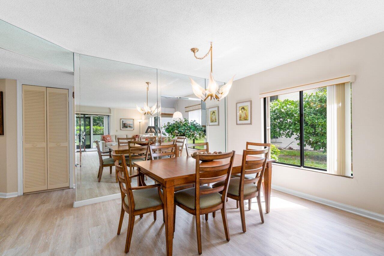 dining room with a notable chandelier, light wood-type flooring, and a textured ceiling