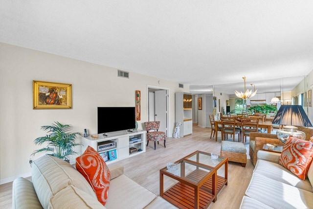 living room featuring a notable chandelier and light hardwood / wood-style floors