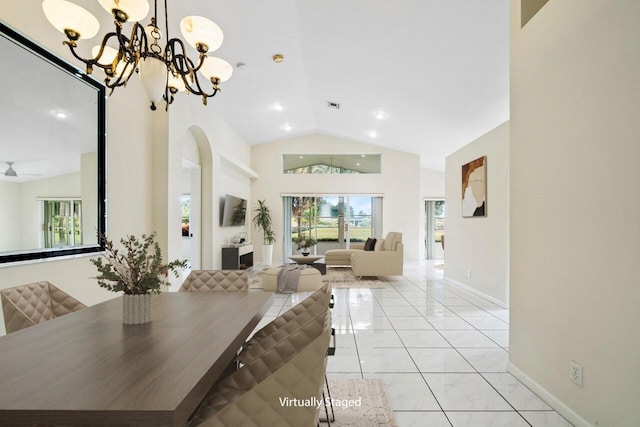 dining area with ceiling fan with notable chandelier, light tile patterned floors, and vaulted ceiling