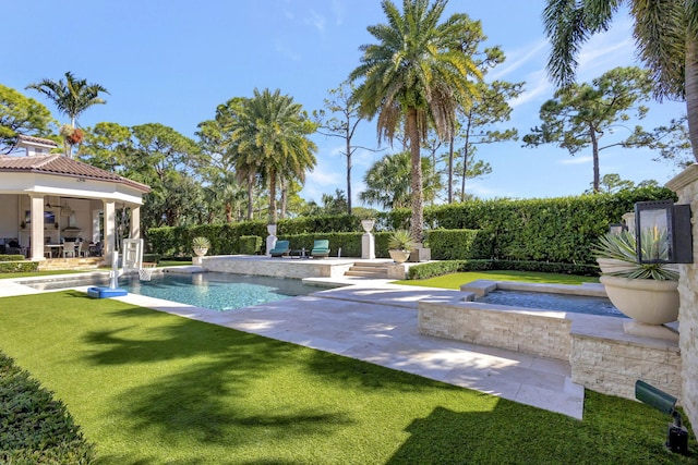 view of swimming pool featuring a jacuzzi, a patio area, and a lawn