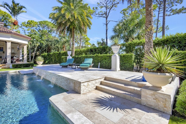 view of pool featuring pool water feature and a patio area