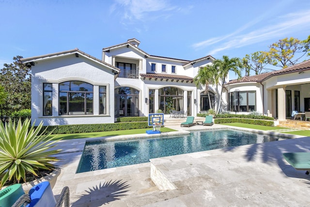 rear view of property with a patio area and a balcony